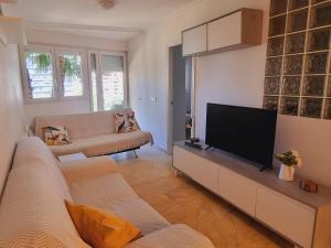 un soggiorno con divano e TV a schermo piatto di Apartamento Puig Campana a Benidorm
