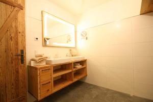 La salle de bains est pourvue d'un lavabo et d'un miroir. dans l'établissement Hütte in der Hütte, à Rauris
