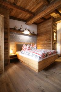 - une chambre avec un lit dans une pièce dotée de murs en bois dans l'établissement Hütte in der Hütte, à Rauris