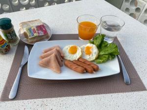 einen Teller mit Eiern und Wurst und ein Glas Orangensaft in der Unterkunft Phala Shore Resort 