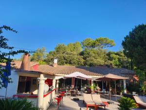 a house with a patio with chairs and tables at Au Mas Saint Pierre in Pignans