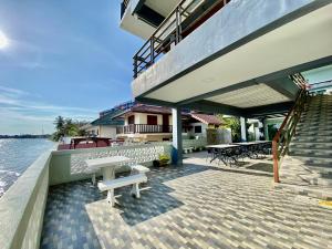 eine Terrasse mit einer Bank und einer Treppe neben dem Wasser in der Unterkunft Phala Shore Resort 
