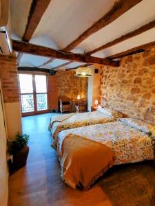 a bedroom with two beds and a stone wall at La Casirria in Olba