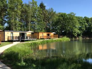 a couple of mobile homes next to a lake at Cedar Boutique Lodge-dog fishing and Spa access in York