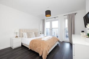 a white bedroom with a large bed and windows at Stylish House with Garden and Parking in Glasgow