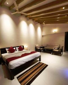 a bedroom with a large bed and a living room at THE INFINITY PENCH RESORT in Khawāsa