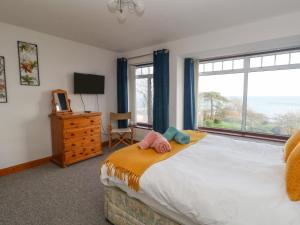 ein Schlafzimmer mit einem Bett und einem großen Fenster in der Unterkunft Kiama in Weymouth