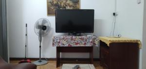 un televisor sentado en una mesa con un ventilador en Paradise Resting Home en Réunion