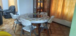 a dining room table with white chairs around it at Paradise Resting Home in Réunion