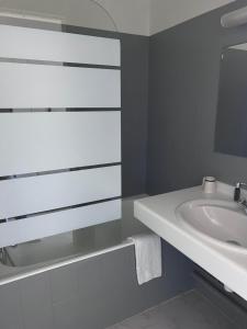 uma casa de banho branca com um lavatório e um espelho em Hostellerie Saint Clément em Vic-sur-Cère
