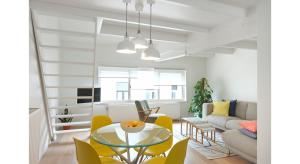 a living room with a glass table and yellow chairs at Centreflat A26 in Ghent