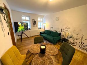 a living room with a table and a green couch at Apartments Dombergblick - Suhl, Stadtmitte in Suhl
