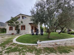 una casa con un árbol y sillas en el patio en Casa Dolce Casa, en Valdobbiadene