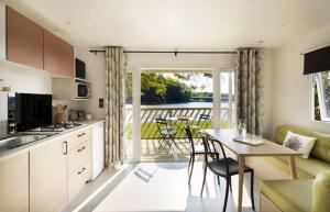 cocina con mesa y sillas y patio en Camping Les Sables Blancs, en Concarneau