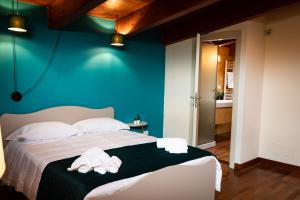 ein Schlafzimmer mit blauer Wand und ein Bett mit Handtüchern in der Unterkunft Borgo Antico B&b in Foggia