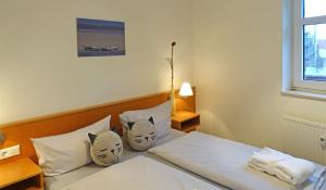 a bedroom with a bed with white sheets and pillows at Inselresidenz Strandburg Juist - Ferienwohnung 308 (Ref. 51039) in Juist