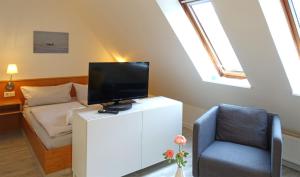 ein Wohnzimmer mit einem TV und einem Stuhl in der Unterkunft Inselresidenz Strandburg Juist - Ferienwohnung 308 (Ref. 51039) in Juist