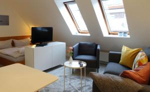 ein Wohnzimmer mit einem TV und 2 Stühlen in der Unterkunft Inselresidenz Strandburg Juist - Ferienwohnung 308 (Ref. 51039) in Juist