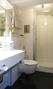 a white bathroom with a toilet and a shower at Inselresidenz Strandburg Juist - Ferienwohnung 308 (Ref. 51039) in Juist