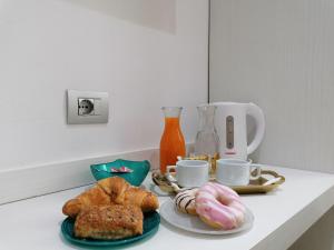 聖特雷莎加盧拉的住宿－Charme Suite B&B Experience，一张桌子,上面放着两盘糕点和咖啡杯