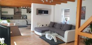 ein Wohnzimmer mit einem Sofa und einer Küche in der Unterkunft Ferienhaus Sabine im Biosphärenreservat Bliesgau in Blieskastel