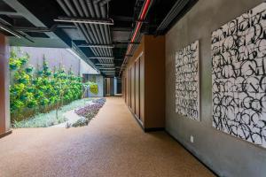 Loft conceito com área privativa في بيلو هوريزونتي: ممر فارغ وبه لوحات على الجدران