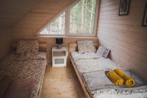 a small room with two beds and a window at Grzybowska Osada in Grzybowo