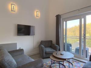 sala de estar con sofá, sillas y mesa en Modern Duplex Apartment with Woodland Views en Swansea