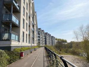 a walkway next to a row of apartment buildings at Modern Duplex Apartment with Woodland Views in Swansea