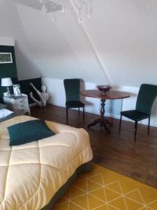Schlafzimmer mit einem Bett, einem Tisch und Stühlen in der Unterkunft La Menardière L'appart' in Corseul