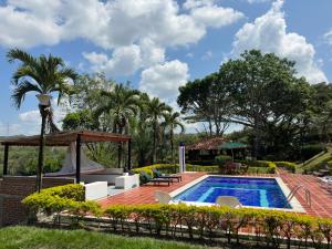 a swimming pool with a patio and a house at Hacienda Daniela 