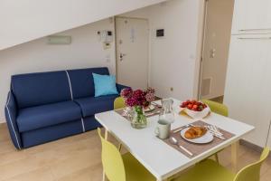 a living room with a table and a blue couch at VastoMare - appartamento Vasto Marina in Vasto