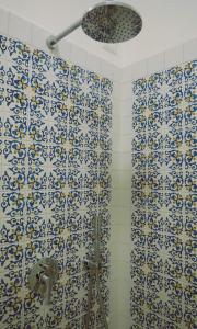 uma casa de banho com um chuveiro com azulejos azuis e brancos em Casa Marrapese em Positano
