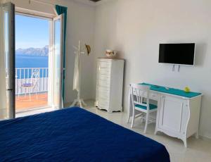 um quarto com uma cama, uma secretária e uma janela em Casa Marrapese em Positano