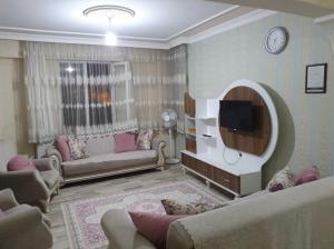 a living room with couches and a flat screen tv at okyanus apart laçin apart in Bostaniçi