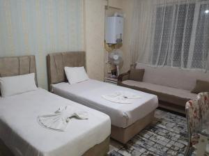 a hotel room with two beds and a couch at okyanus apart laçin apart in Bostaniçi