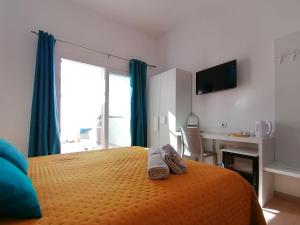 Dormitorio con cama, escritorio y TV en Charme Suite B&B Experience en Santa Teresa Gallura