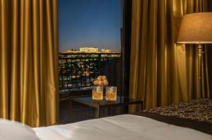 a bedroom with a window with a view of a city at Astor Hotel in Athens