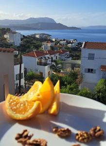 an orange on a plate with a view of a city at Bicorna - Chania in Plaka