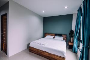 1 dormitorio con cama y pared azul en The Living Hotel SamutPrakan en Bang Bo