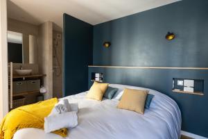 a bedroom with a large white bed with blue walls at Villa Nymphéa - maison avec piscine chauffée St Gildas de Rhuys in Saint-Gildas-de-Rhuys +17 photos