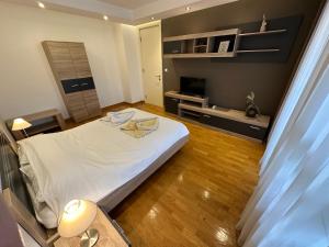 una camera con letto bianco e TV di Nevena Belville Apartments a Belgrado