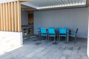 une salle à manger avec des chaises bleues et une table dans l'établissement Villa Nymphéa - maison avec piscine chauffée St Gildas de Rhuys, à Saint-Gildas-de-Rhuys