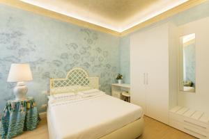 een slaapkamer met een bed en een muur met bloemenbehang bij Flat Volturno- Florentine neighbourhood in Florence