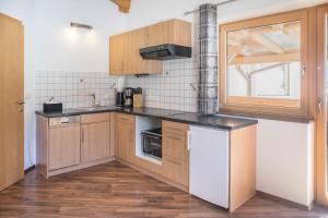 a small kitchen with wooden cabinets and a window at Appartement Julia in Achenkirch