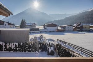 un pueblo cubierto de nieve con una montaña en el fondo en Appartement Julia, en Achenkirch