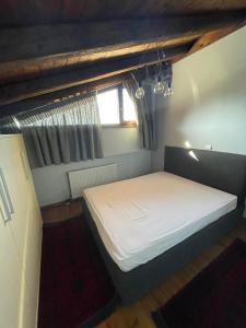 Ce lit se trouve dans une petite chambre dotée d'une fenêtre. dans l'établissement Arachova Luxury Chalet, à Arachova