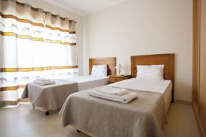 um quarto de hotel com duas camas e uma janela em Apartamento Duja em Cabanas de Tavira