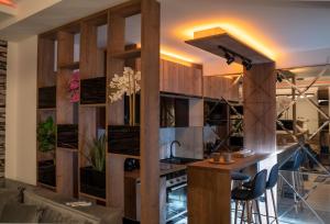 - une cuisine avec des murs en bois et un bar avec des tabourets dans l'établissement Geregs alibi - free Spa, à Kopaonik