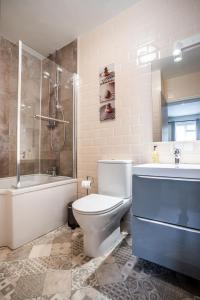 a bathroom with a toilet and a tub and a shower at Black Horse Hotel in Grassington